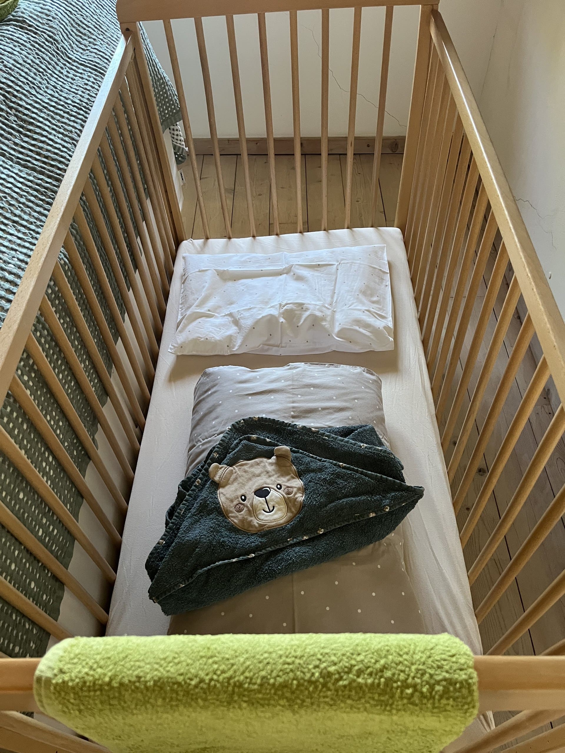Gitterbett mit Kapuzenhandtuch neben dem Doppelbett in der Casa Grande.