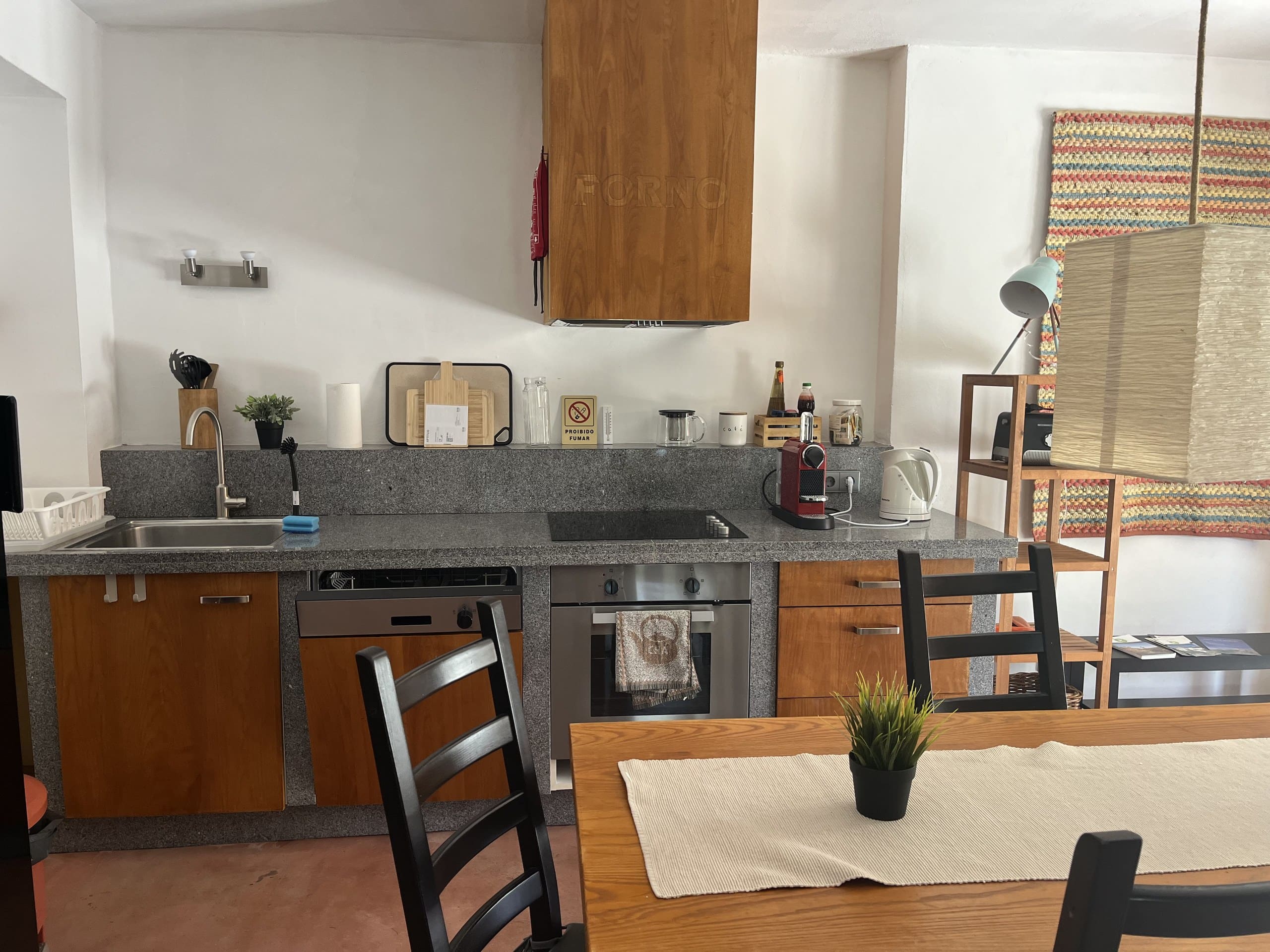 Küchenzeile der Casa Terra mit Granitarbeitsplatte, Spüle, Backofen und Kochfeld.