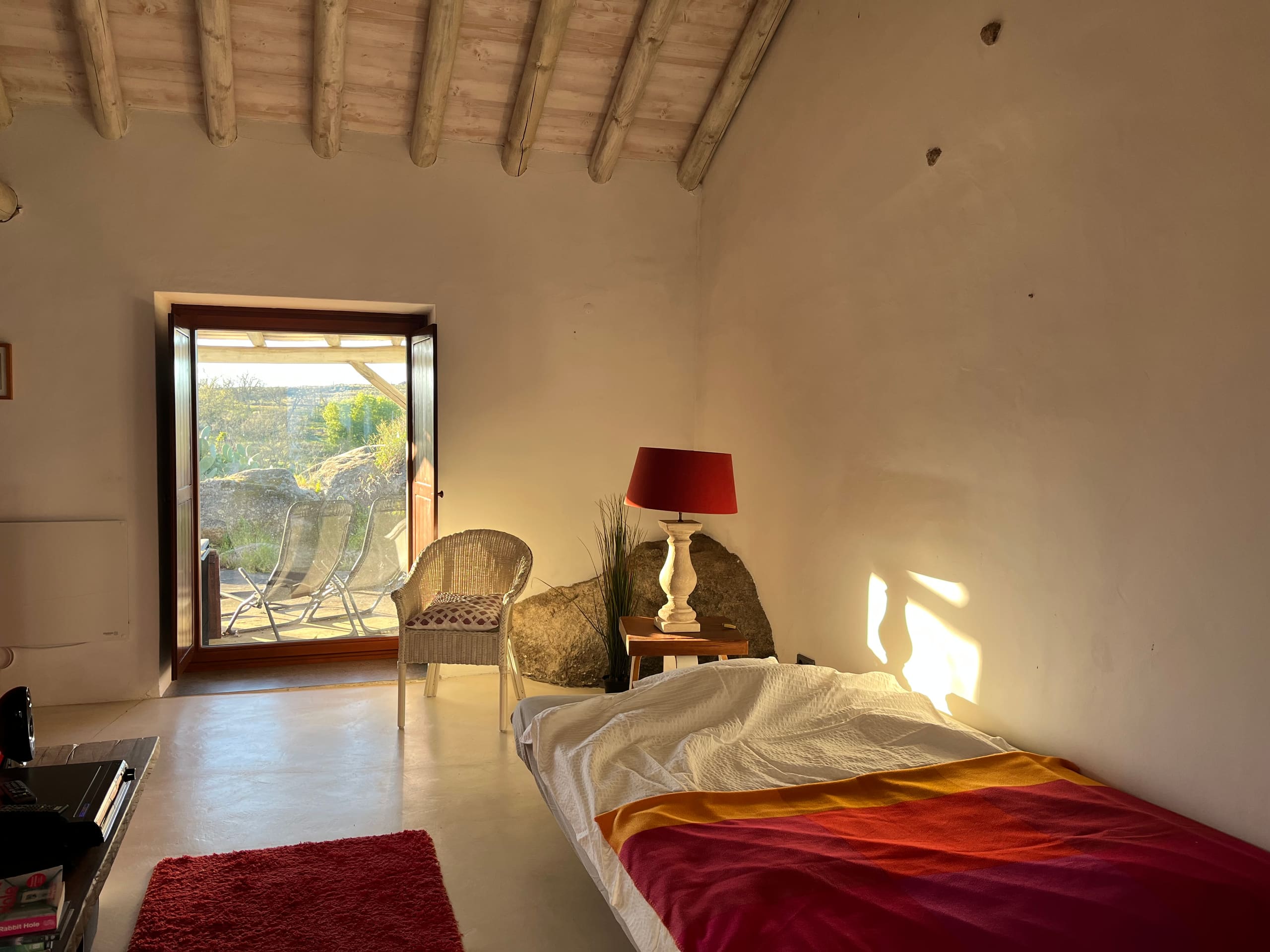Wohnraum der Casa Amor Perfeito im Abendlicht, das Sofa ist als Bett aufgeklappt.