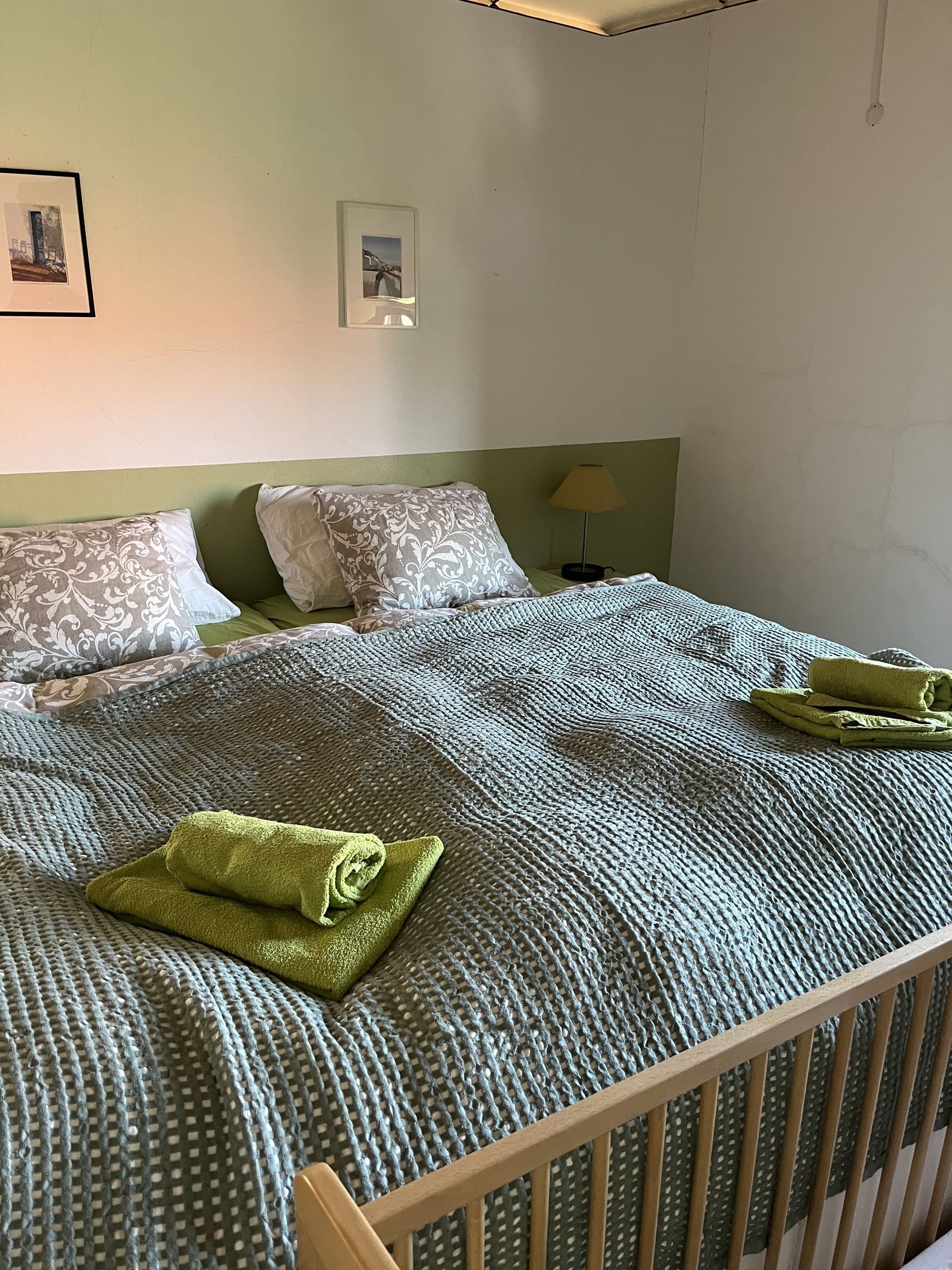 Doppelbett mit bereitgelegten Handtüchern im grünen Schlafzimmer der Casa Grande.