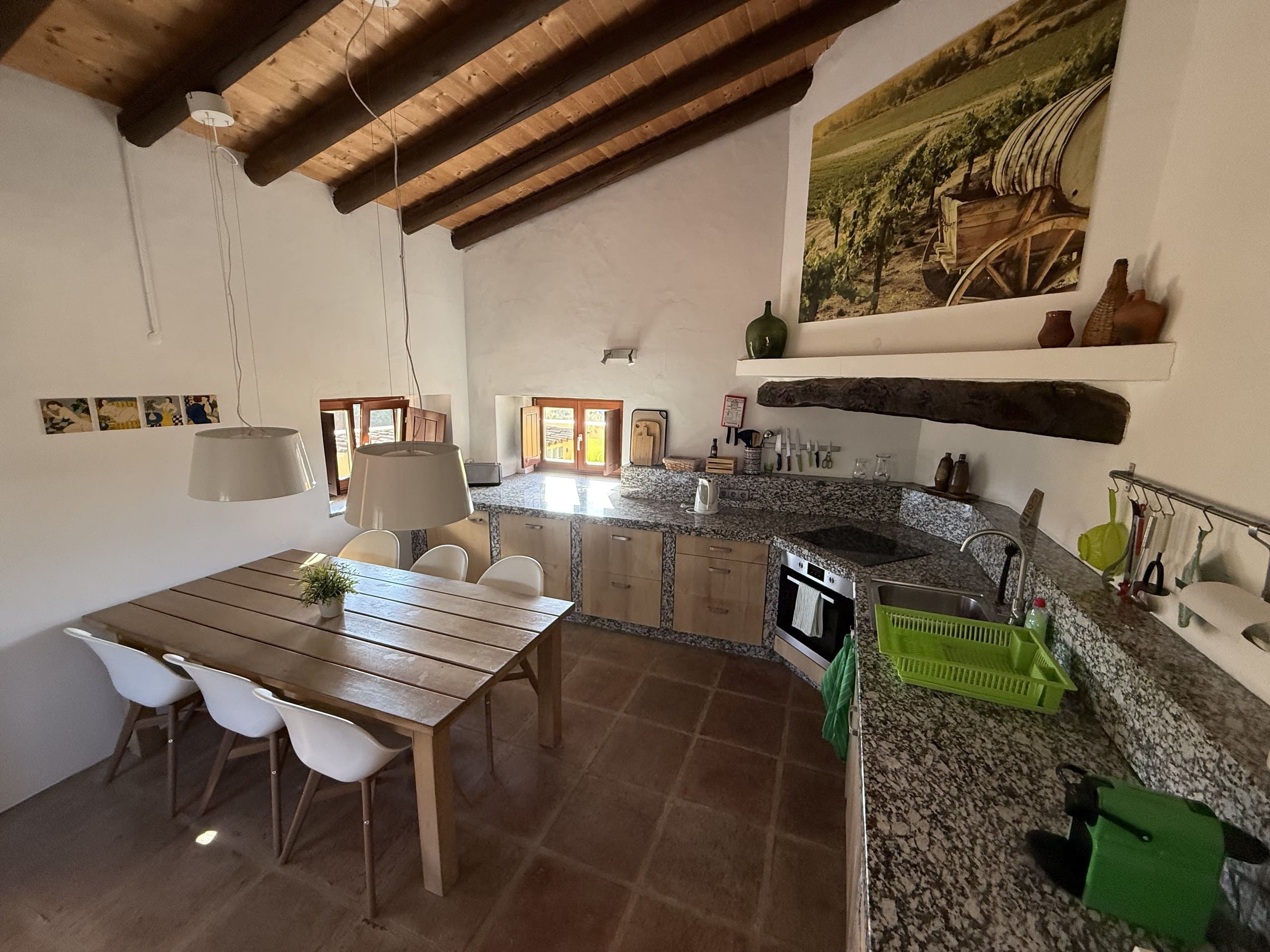 Wohnküche der Casa Grande mit Esstisch, Granitarbeitsplatte und Balkendecke.