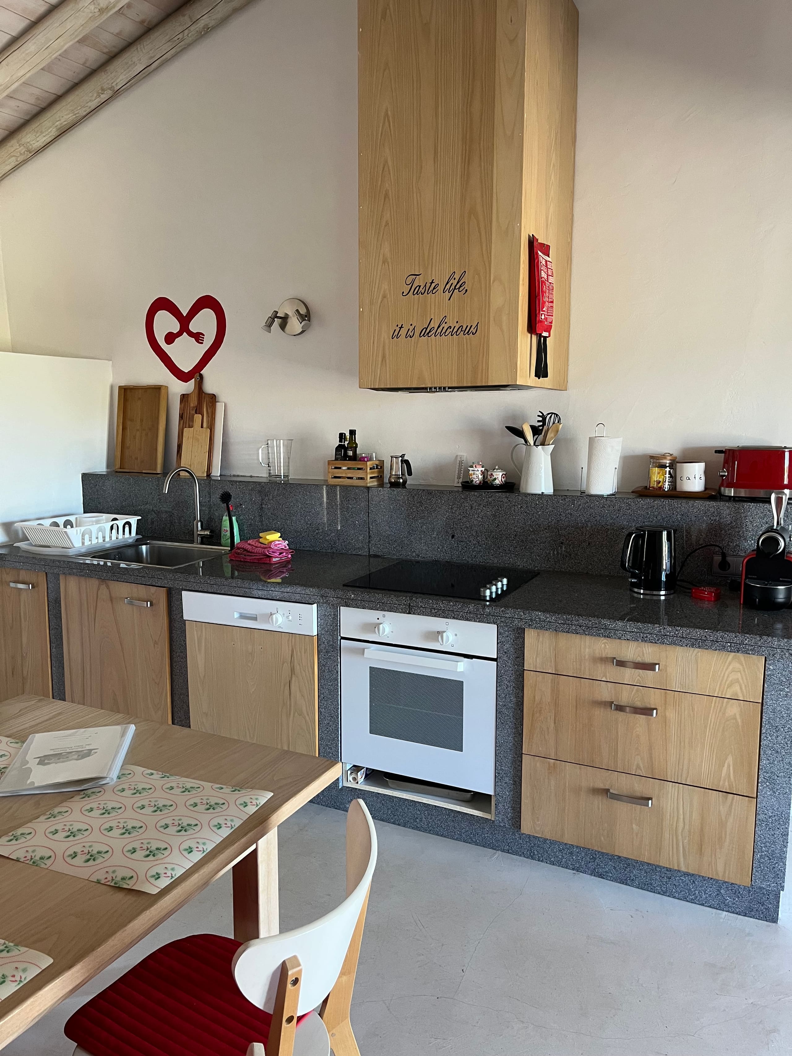Küche der Casa Amor Perfeito mit Backofen, Geschirrspüler und Hängeschränken.