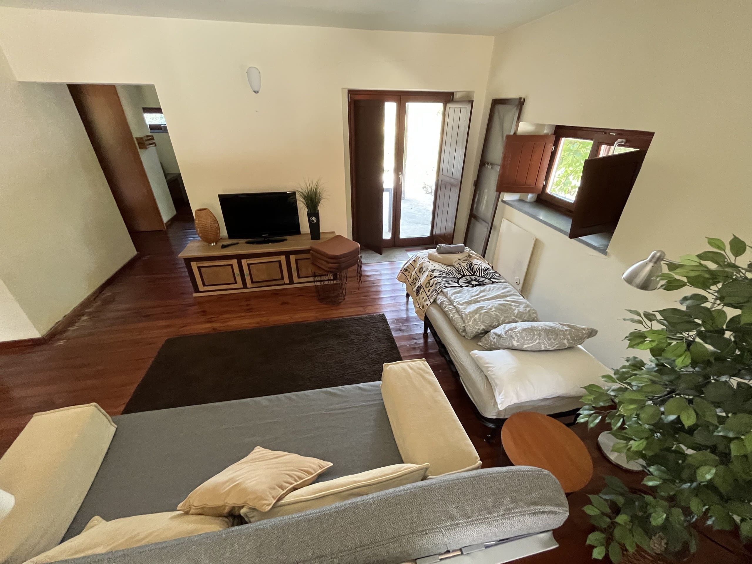 Blick über den Wohnraum der Casa Hridaya zur geöffneten Terrassentür.