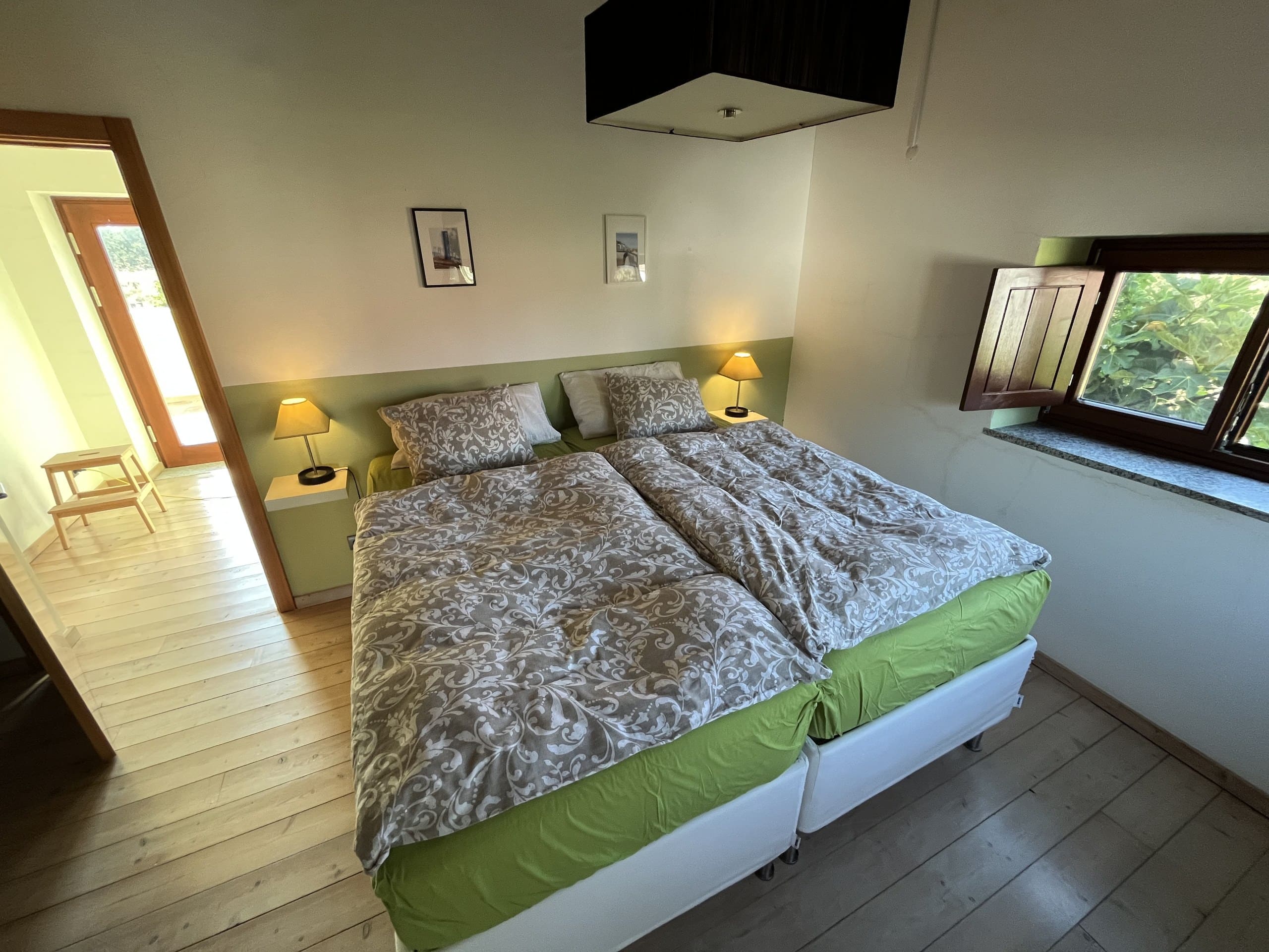 Schlafzimmer mit grüner Wand und Doppelbett in der Casa Grande.