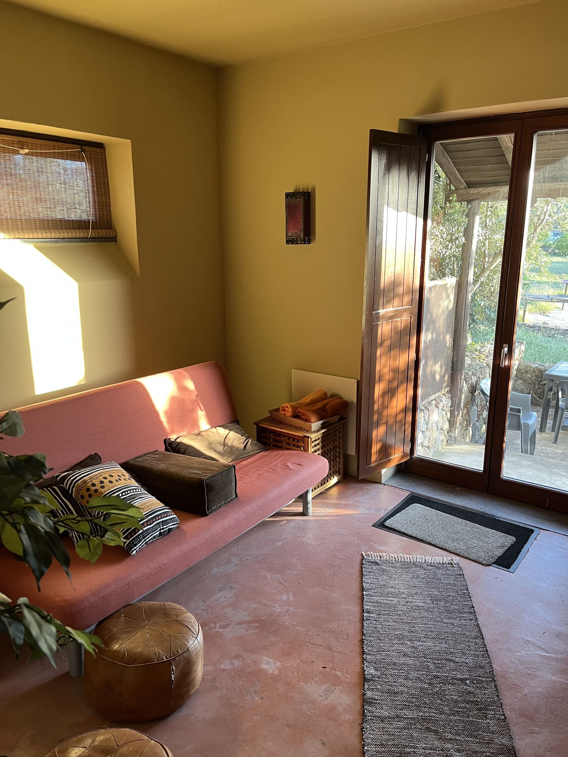 Tagesbett mit rosafarbenem Bezug am Fenster zum Garten in der Casa Terra.
