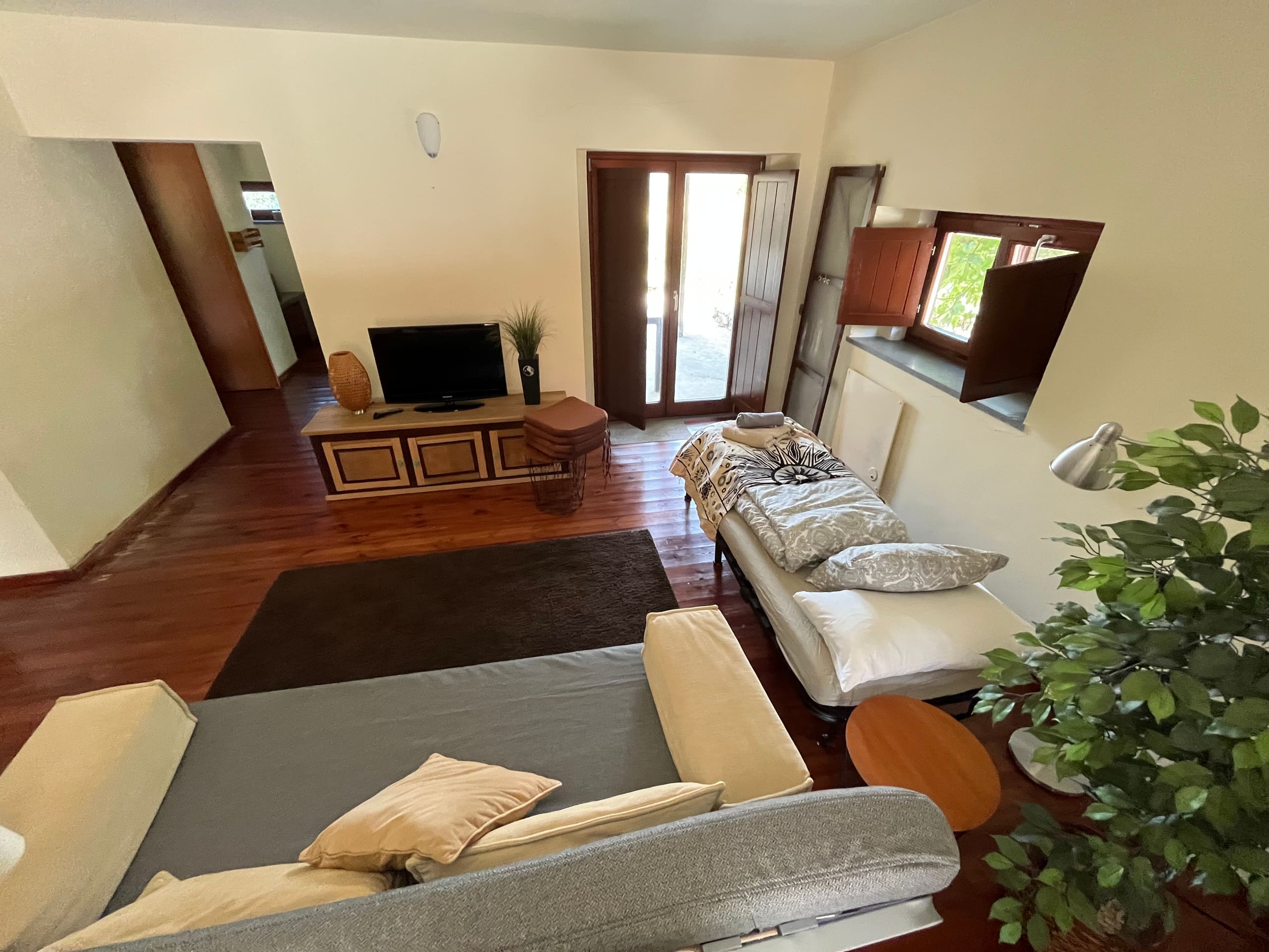 Blick über den Wohnraum der Casa Hridaya zur geöffneten Terrassentür.