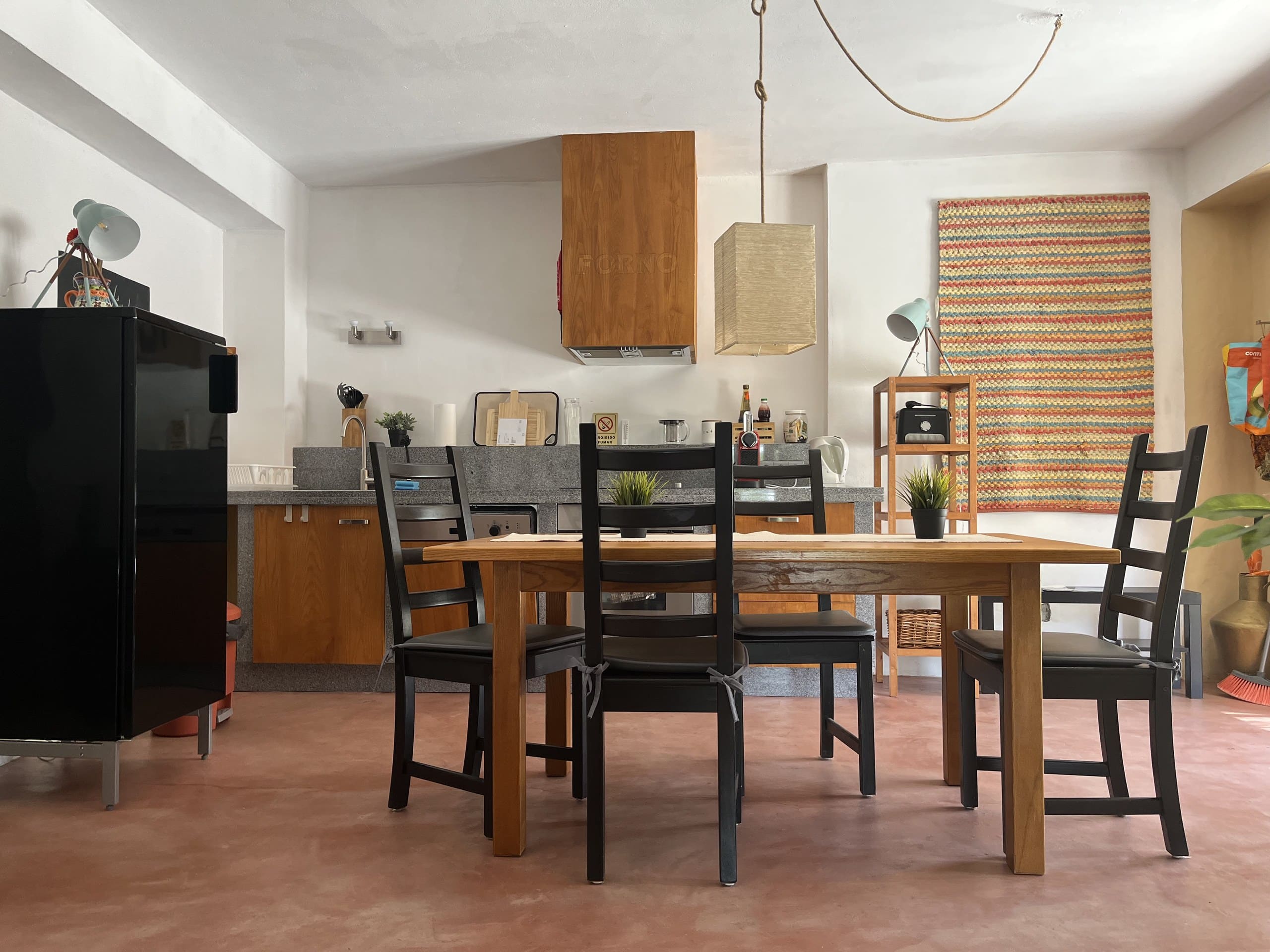 Küche der Casa Terra mit Esstisch, vier Stühlen und Kühlschrank.