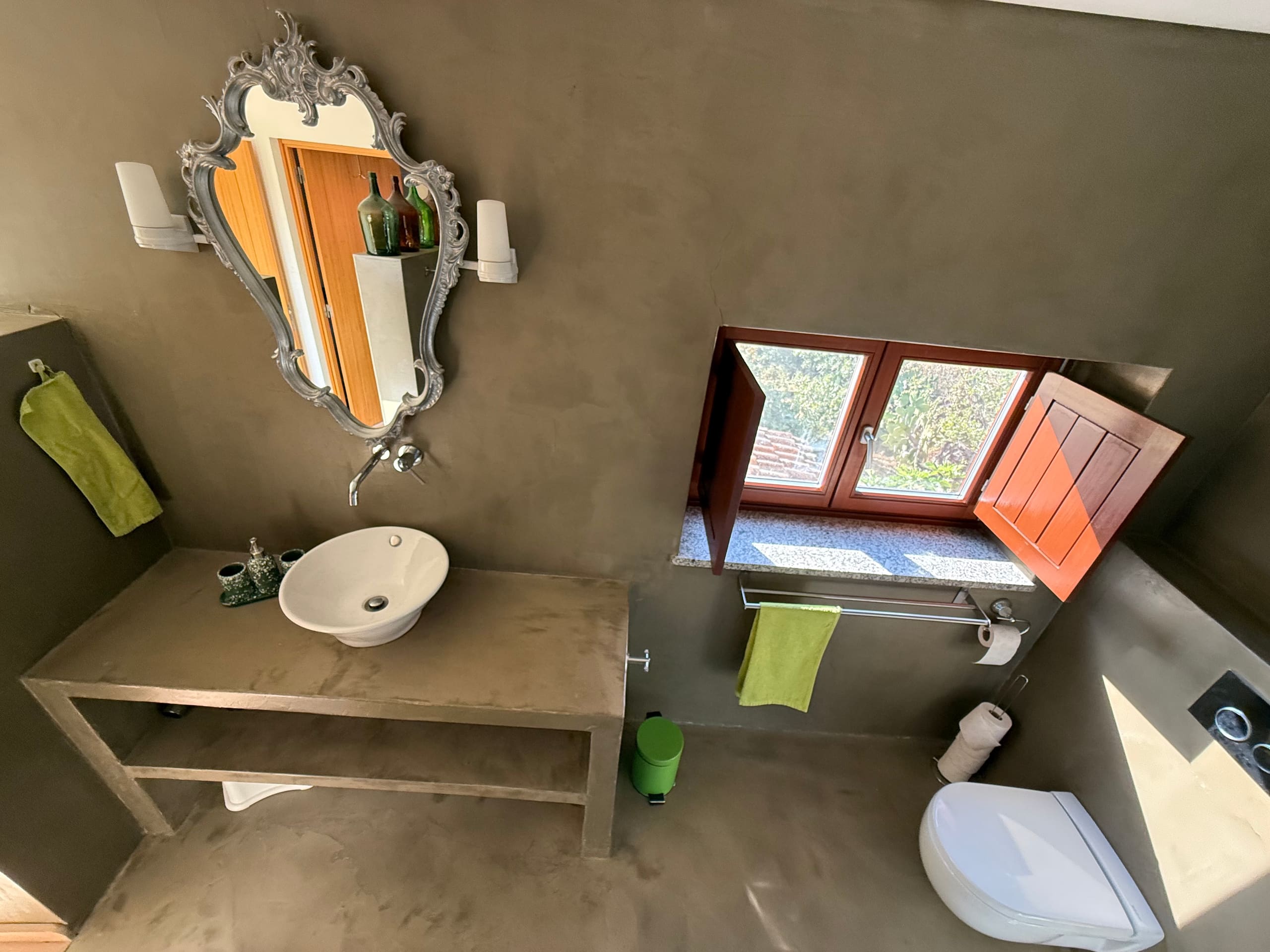 Bad der Casa Grande mit Aufsatzwaschbecken, Zierspiegel und geöffnetem Fenster.