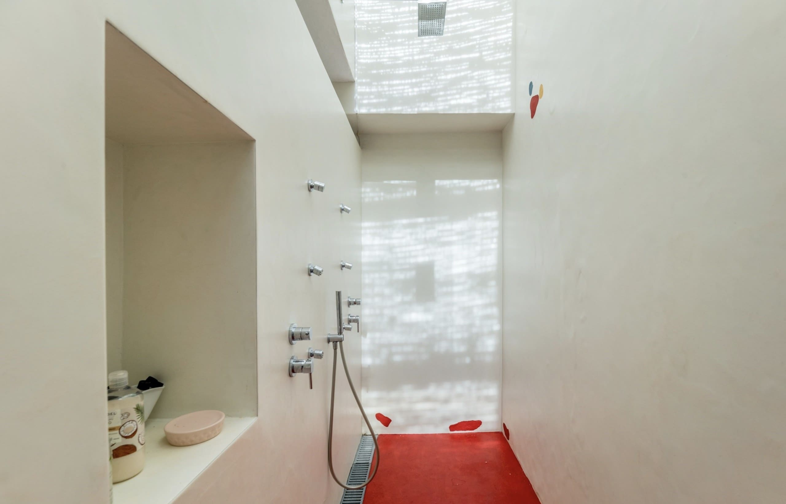Begehbare Regendusche mit rotem Boden in der Casa Amor Perfeito.