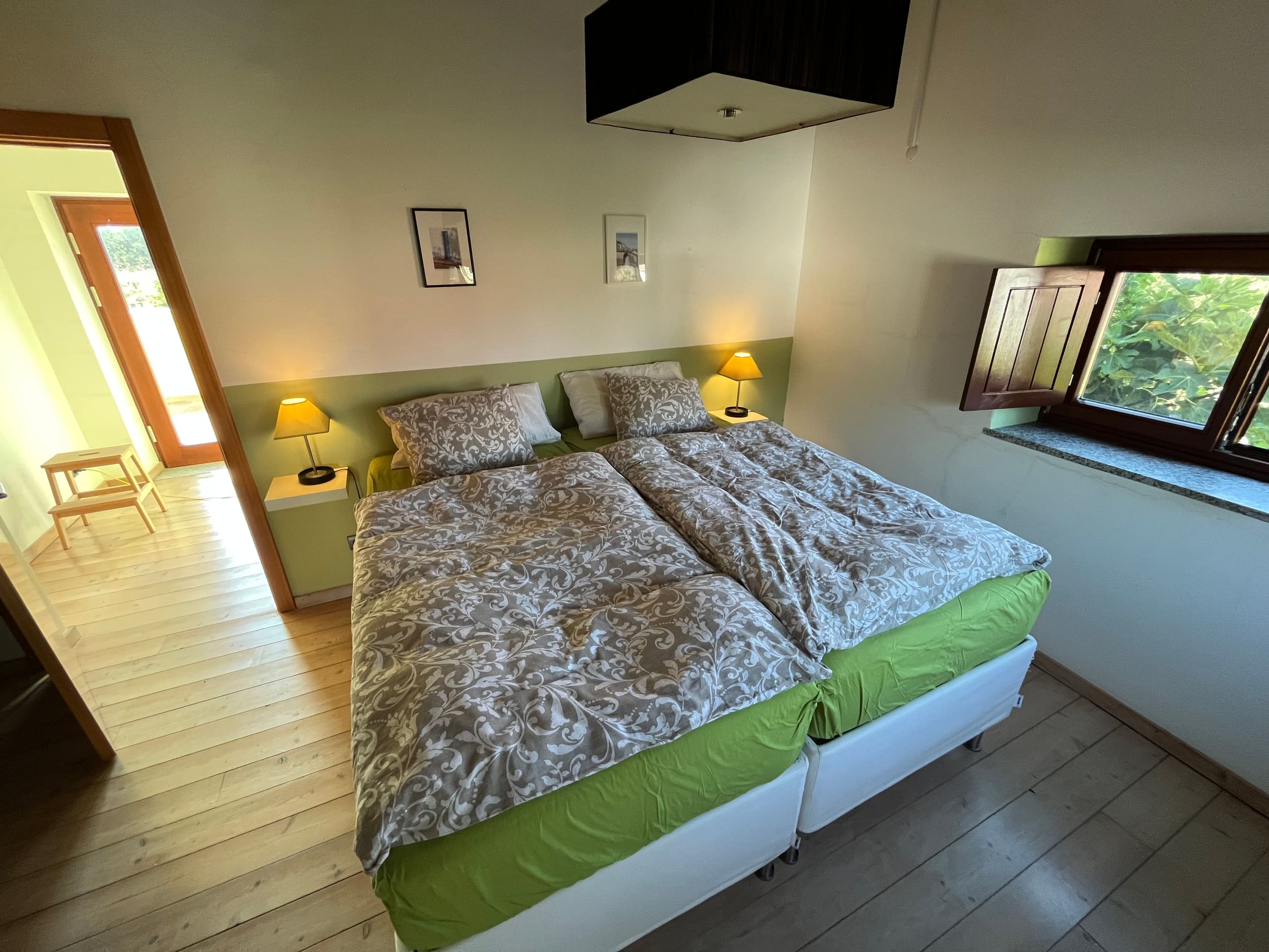 Schlafzimmer mit grüner Wand und Doppelbett in der Casa Grande.