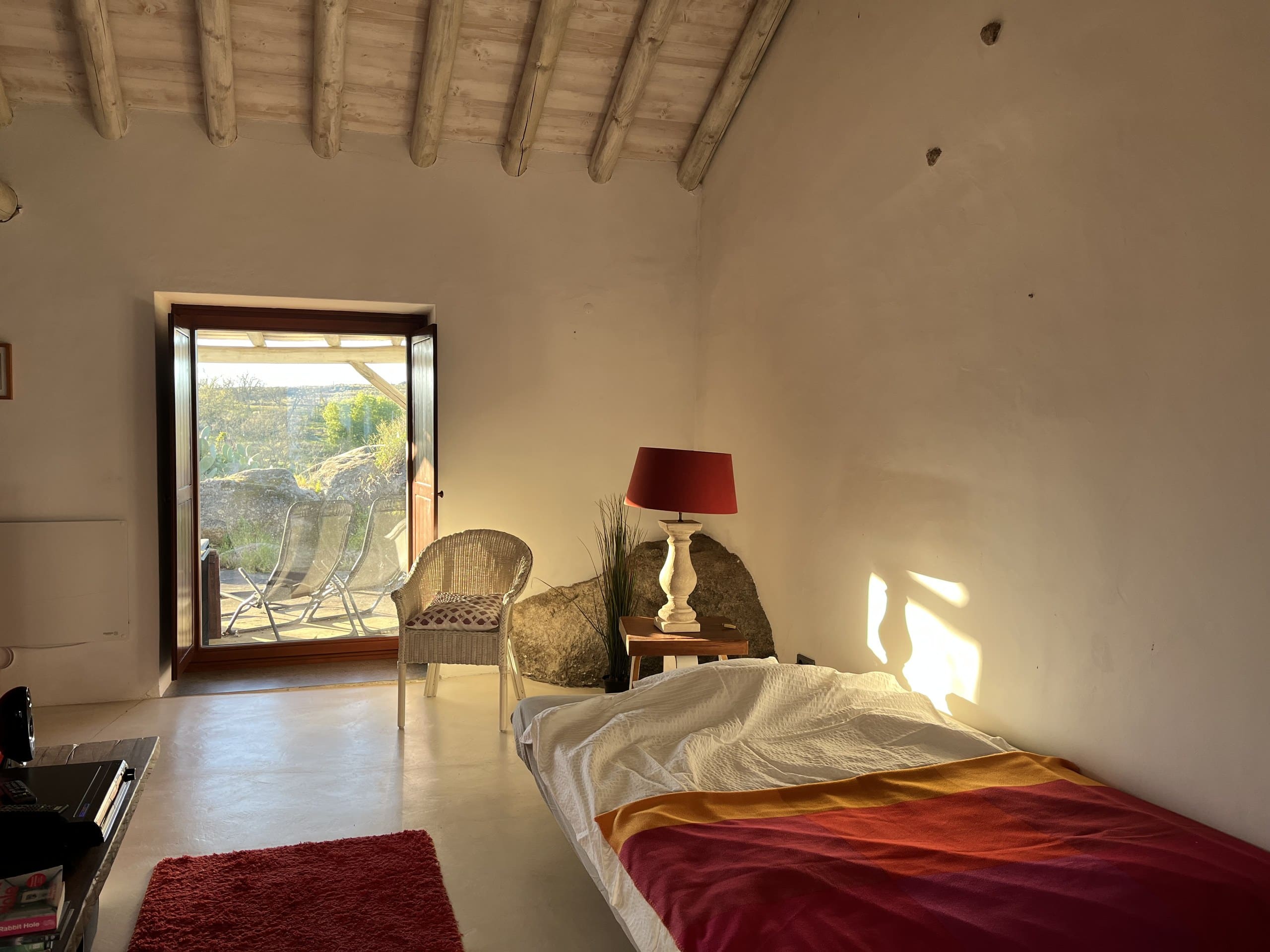 Wohnraum der Casa Amor Perfeito im Abendlicht, das Sofa ist als Bett aufgeklappt.