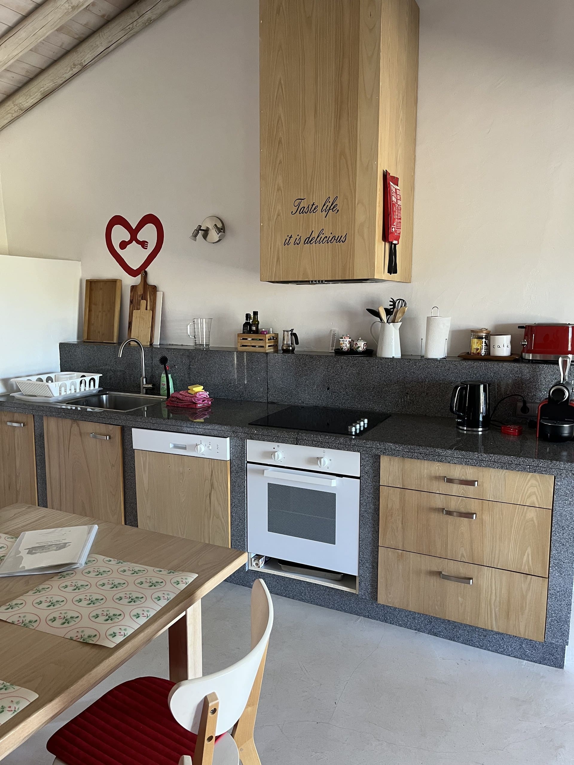 Küche der Casa Amor Perfeito mit Backofen, Geschirrspüler und Hängeschränken.