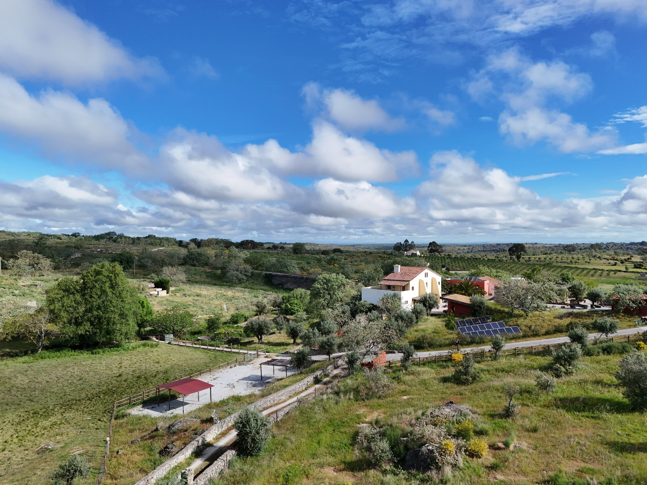 Die Quinta Serra de São Mamede aus der Luft, mit Solarmodulen, überdachtem Stellplatz und weitem Himmel über dem Alentejo.