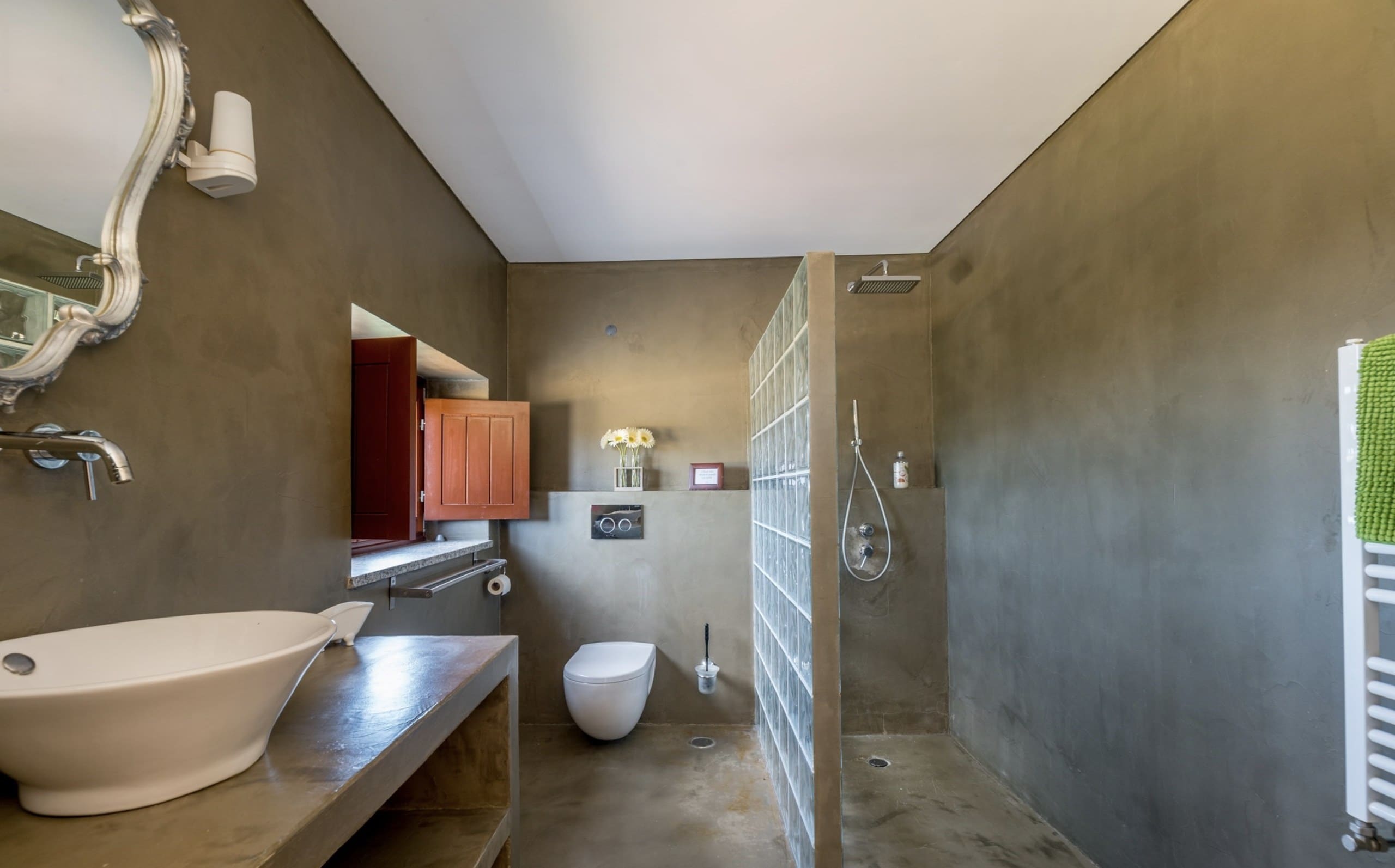 Regendusche hinter einer Glasbausteinwand im Bad der Casa Grande.